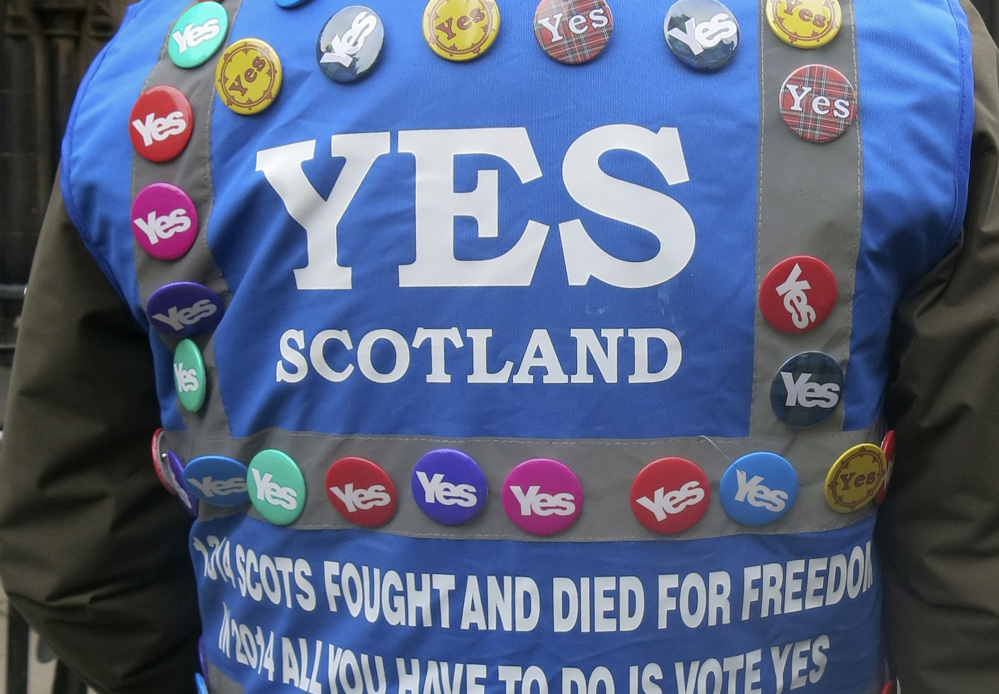 A man wears a multitude of ‘yes’ campaign badges during a march in Scotland.