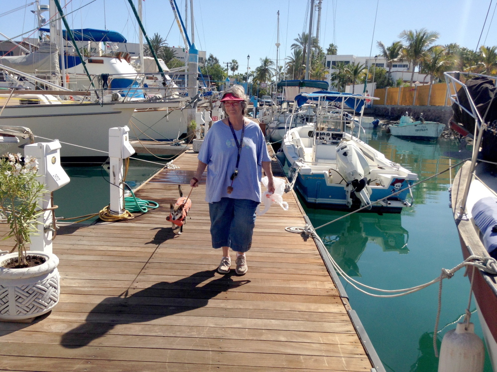Allyson van Os of Dallas walks on the dock with her dog Pequena. She and her husband, Ed, live on their boat in La Paz, Mexico, from October to June.
