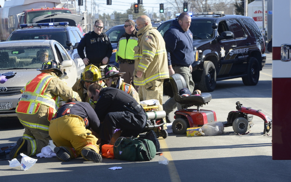 Windham fire and rescue personnel stabilize a man who was hit by a car as he tried to cross Route 302 while riding on an electric scooter in front of a shopping center.