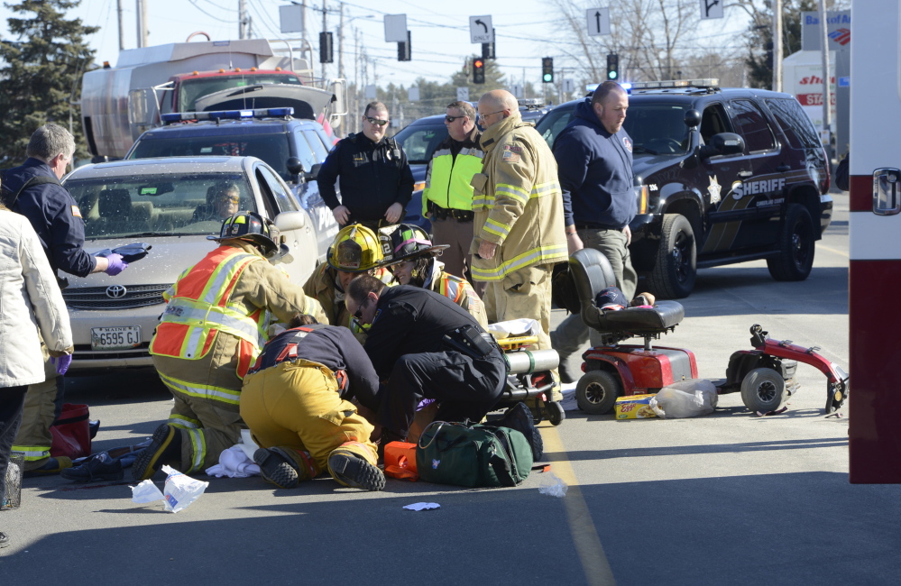 Windham fire and rescue personnel stabilize a man who was hit by a car as he tried to cross Route 302 in his wheelchair in front of a Windham shopping center.