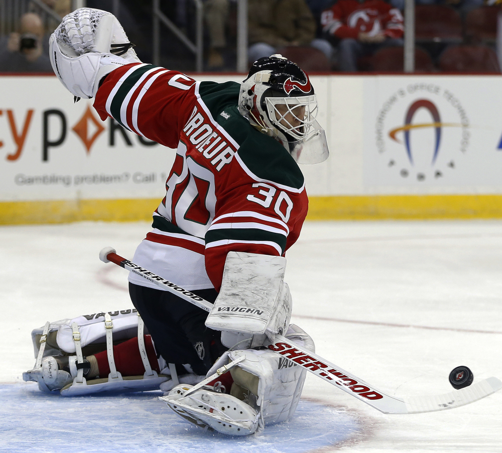 New Jersey Devils goalie Martin Brodeur makes a save on a shot by the Boston Bruins during the first period of an NHL hockey game, Tuesday, March 18, 2014, in Newark, N.J.