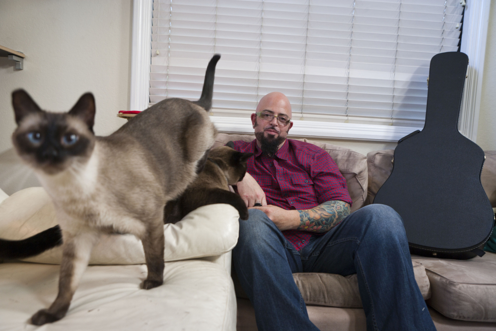 This undated photo provided by the Animal Planet shows cat behaviorist Jackson Galaxy host of the Animal Planet television show “My Cat from Hell” with Sully and Lulu in the Sherman Oaks area of Los Angeles.
