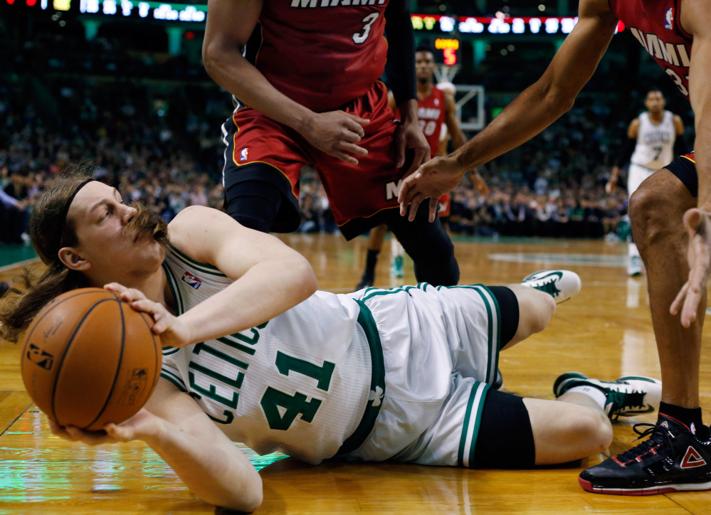 Kelly Olynyk of the Boston Celtics looks to pass from the floor Wednesday night as Miami Heat defenders attempt to trap him. The Celtics came away with a 101-96 victory.