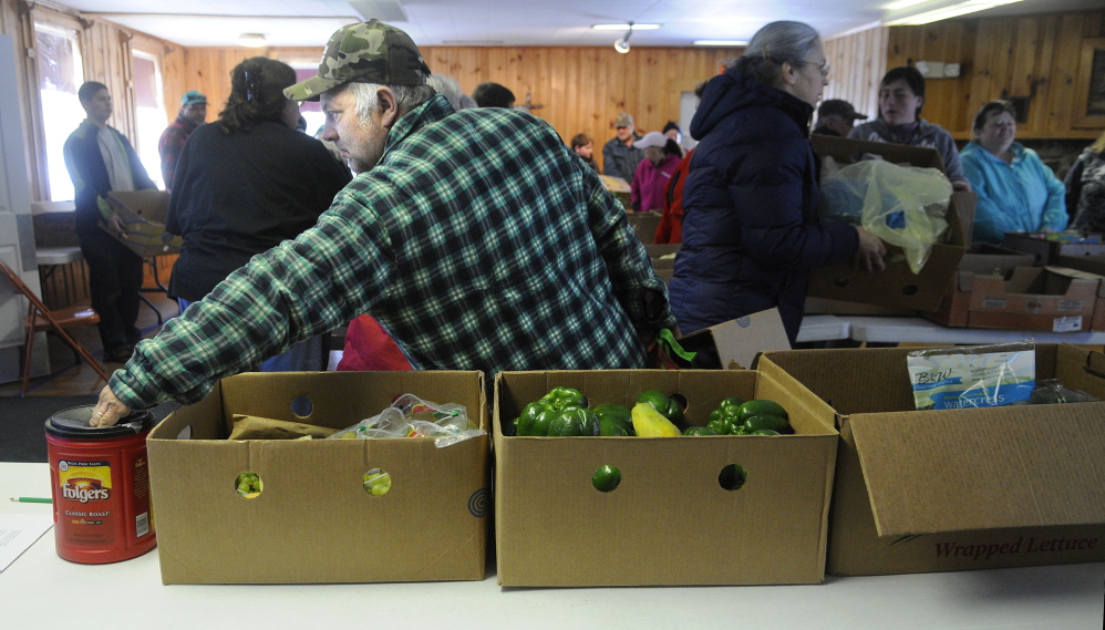 Douglas Mason Sr. of Augusta makes a contribution Tuesday at the East Winthrop Baptist Church Food Ministry before collecting fruit, vegetables and other perishable items that were donated by Hannaford.