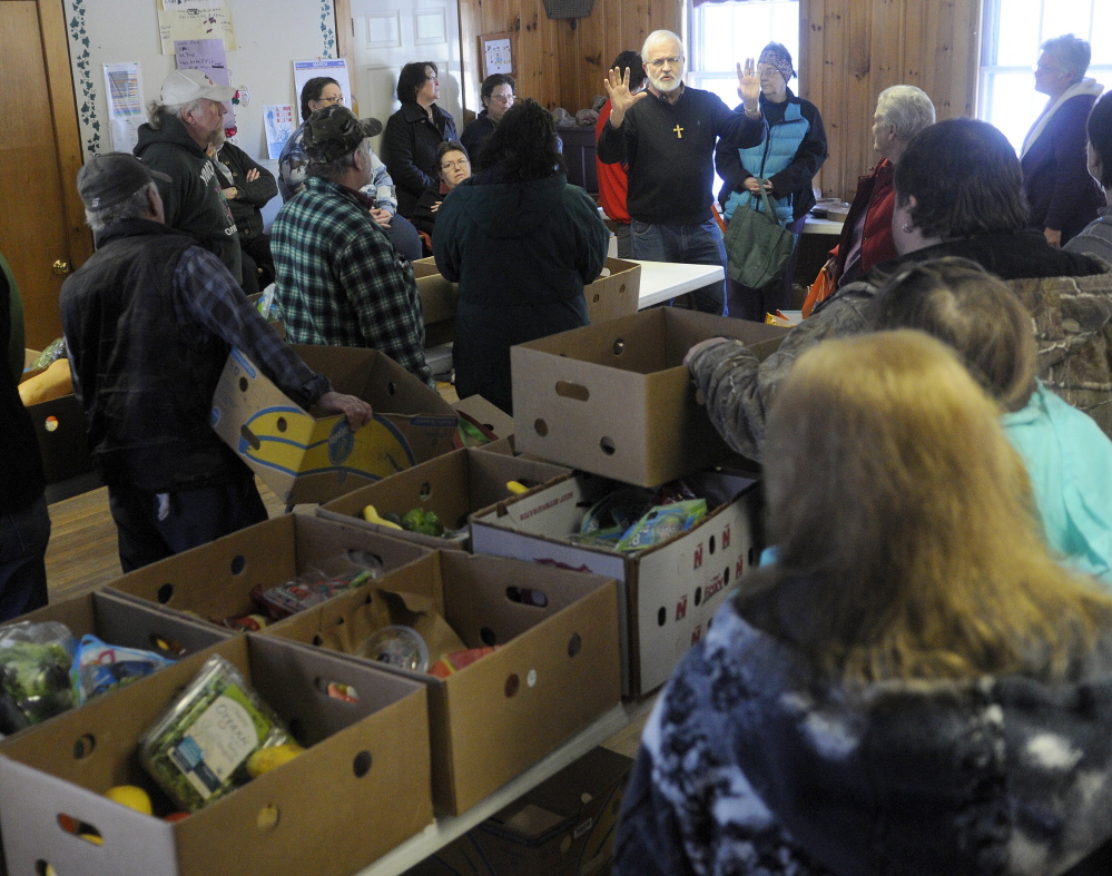 Pastor Sam Richards tells customers at the East Winthrop Baptist Church Food Ministry on Tuesday that Hannaford will no longer give to food pantries unaffiliated with Good Shepherd Food Bank.
