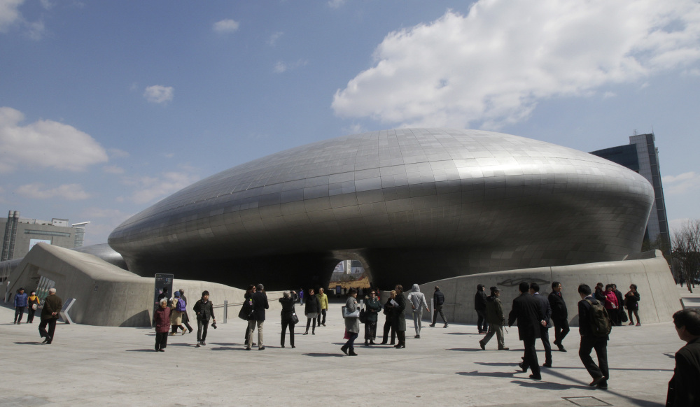 Visitors are dwarfed by Dongdaemun Design Plaza in Seoul, South Korea.