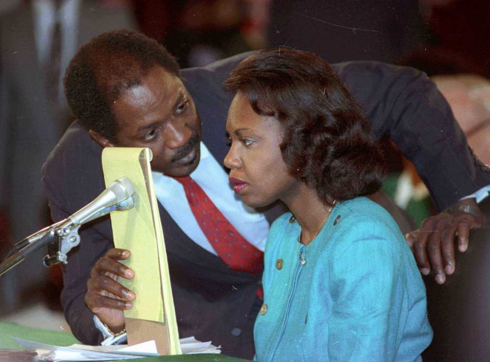 Counsel Charles Ogeltree uses a legal pad to cover a microphone as he advises law professor Anita Hill on Oct. 11, 1991, during hearings on Judge Clarence Thomas.