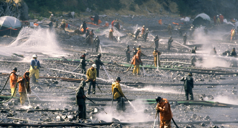 Exxon Valdez oil spill workers use high-pressure hoses to wash oil from the beach at Smith Island on Alaska’s Prince William Sound in April 1989.