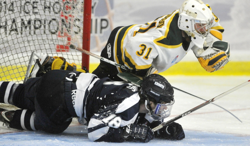 St. Norbert goalie David Jacobson gets taken down by a sliding Stephen Collins of SUNY-Geneseo during St. Norbert’s 6-2 victory. The Green Knights pulled away from a 2-2 tie late in the second period.