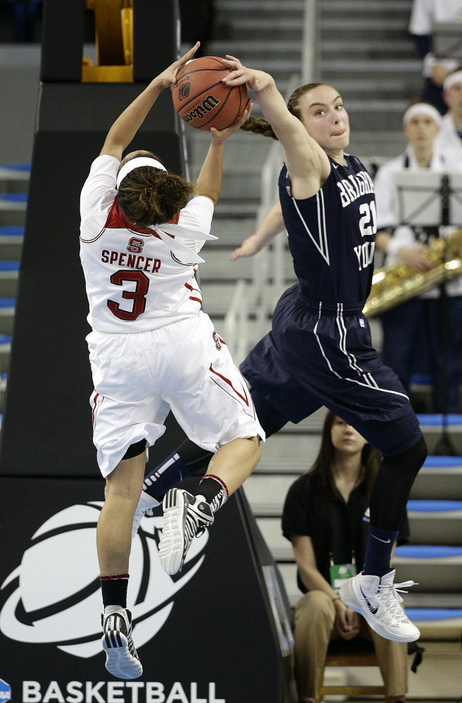 BYU’s Lexi Eaton, right, blocks a shot by North Carolina State’s Miah Spencer during the first half of a first-round game in the NCAA women’s college basketball tournament on Saturday.