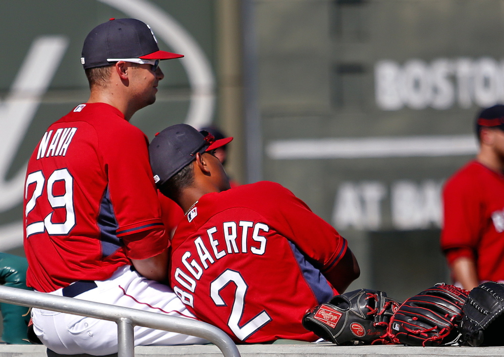 Daniel Nava and Xander Bogaerts take a break before a spring training game at JetBlue Park last Thursday. Of last year’s champions, Manager John Farrell said: “That was the closest team I’ve been around in 30 years of professional baseball.”