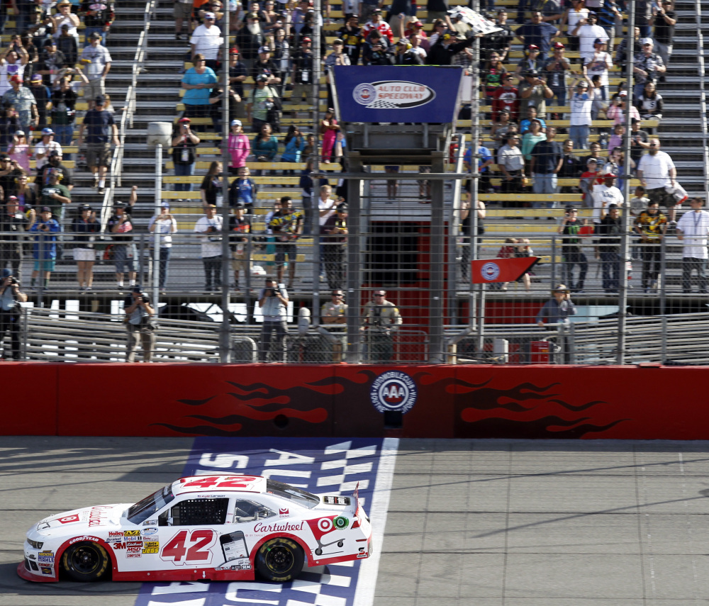Kyle Larson crosses the finish line to win his first NASCAR Nationwide Series auto race, as he held off Kevin Harvick and Kyle Busch at Fontana, Calif., on Saturday. Larson, 21, is regarded as one of NASCAR’s promising young drivers.