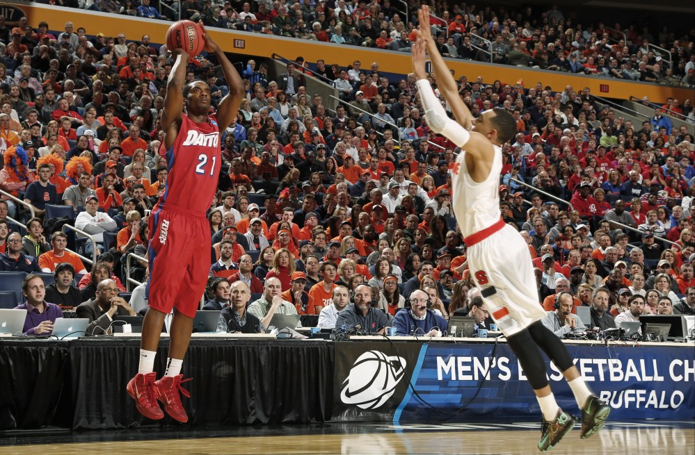 Dayton’s Dyshawn Pierre (21) shoots over Syracuse’s Tyler Ennis (11) during the first half of a third-round game in the NCAA men’s college basketball tournament in Buffalo, N.Y., Saturday.