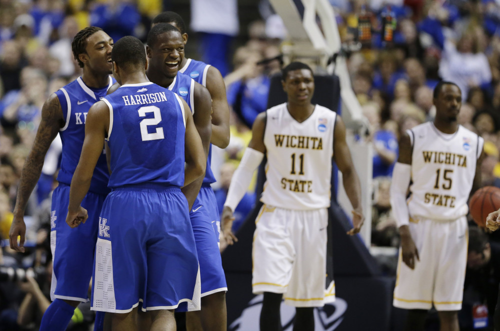 Kentucky players from left, guard/forward James Young (1), guard Aaron Harrison (2) and forward Julius Randle (30) celebrate against Wichita State during the second half of a third-round game of the NCAA college basketball tournament Sunday.