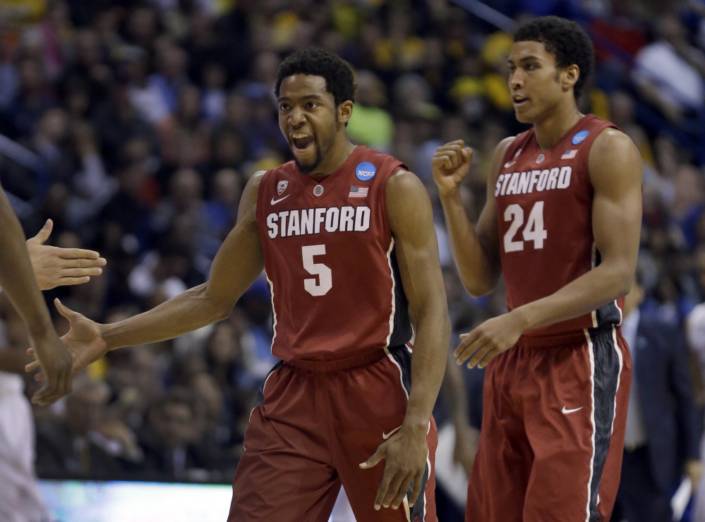 Stanford’s Chasson Randle, left, and Josh Huestis celebrate during the second half of Sunday’s third-round game against Kansas in the NCAA tournament in St. Louis. Stanford, seeded 10th, knocked off No. 2 Kansas to reach the Sweet 16.