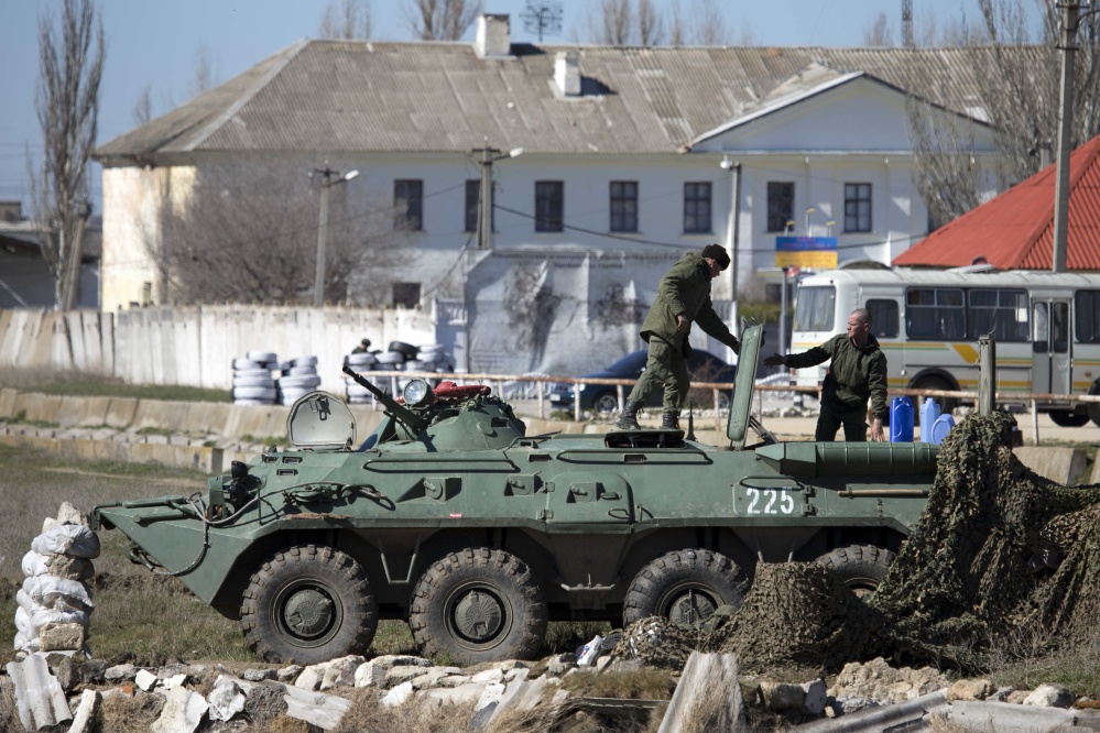 Pro-Russian soldiers in unmarked uniforms arrange a position on top an APC near Ukrainian marines base in the city of Feodosia, Crimea, on Sunday.