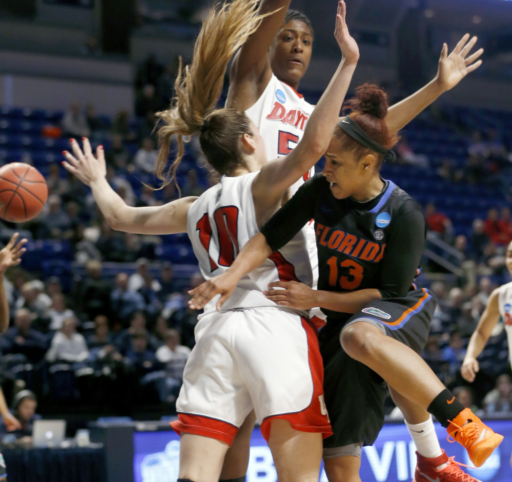 Florida’s Cassie Peoples, right, passes around Dayton’s Andrijana Cvitkovic and in front of Celeste Edwards.