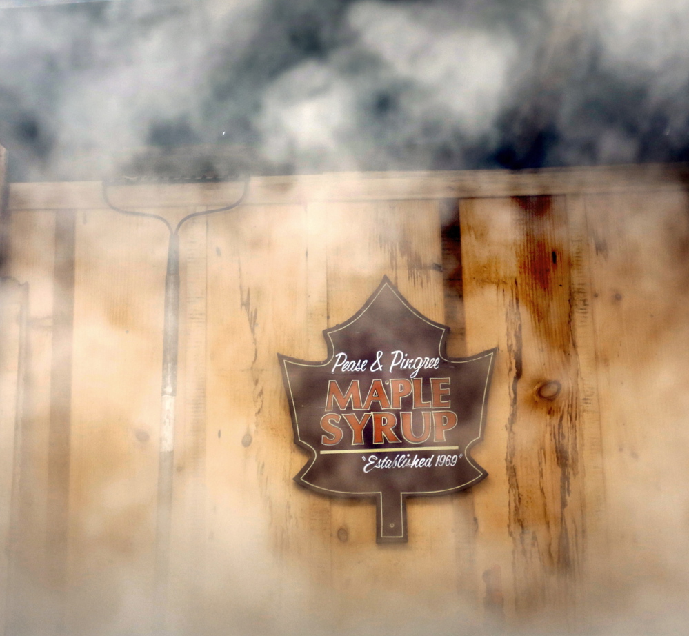Steam from a wood-fired evaporator surrounds a sign hanging in a sugar house at Pingree Maple Products in Cornish during Maine Maple Sunday. As the water evaporates from the sap, what’s left gets thicker and sweeter.
