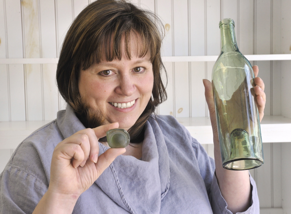 Danielle Perreault holds a “kick up” piece of sea glass similar to the one in a circa 1800s wine bottle. Former first lady Barbara Bush plans to donate sea glass collected at Walker’s Point to Perreault’s new Sea Glass Center.