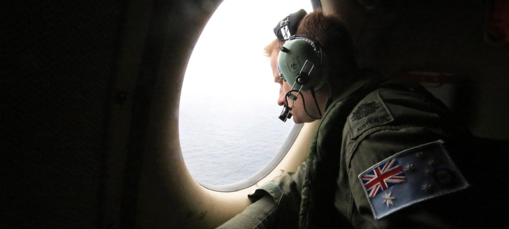 Royal Australian Air Force Warrant Officer Michal Mikeska looks for signs of a crashed airliner from a plane flying over the Indian Ocean.