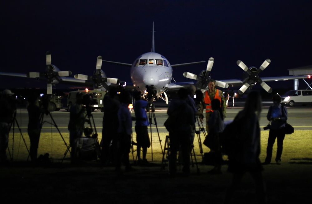International press gather around a Royal Australian Air Force AP-3C Orion upon its return from a search for Malaysian Airlines flight MH370 over the Indian Ocean, at RAAF Base Pearce north of Perth, March 24, 2014. An Australian navy ship was close to finding possible debris from a missing Malaysia Airlines jetliner on Monday as a mounting number of sightings of floating objects raised hopes wreckage of the plane may soon be found. The HMAS Success should reach two objects spotted by Australian military aircraft by Tuesday morning at the latest, Malaysia's government said, offering the first chance of picking up suspected debris from the plane. REUTERS/Jason Reed (AUSTRALIA - Tags: MILITARY TRANSPORT DISASTER MEDIA) - RTR3IC1H