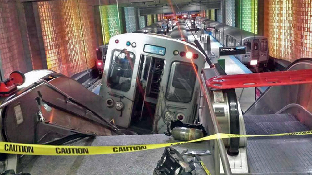 A Chicago Transit Authority train car rests on an escalator at the O’Hare Airport station after it derailed early Monday in Chicago. The train appeared to have been going too fast as it approached the end-of-the-line station and didn’t stop at a bumping post – a metal shock absorber at the end of the tracks.