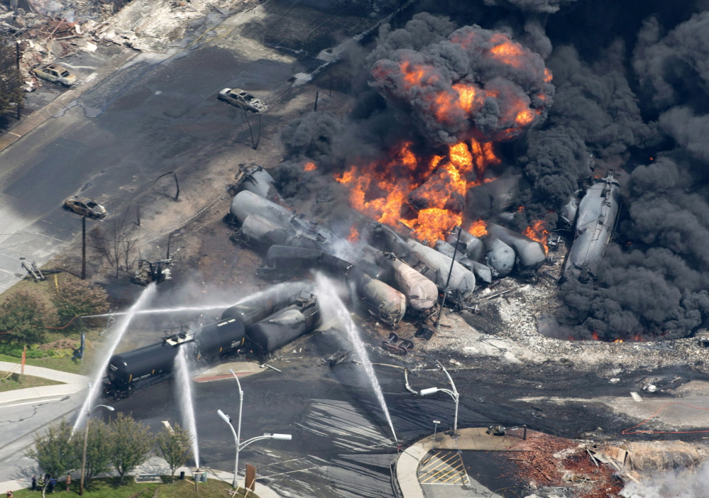 Photo from July 6, 2013 shows smoke rising from railway cars carrying crude oil that derailed in downtown Lac-Megantic, Quebec. A runaway train hurtled down an incline and slammed into downtown Lac-Megantic, where several railway cars exploded.