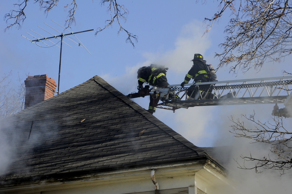 Portland firefighters probe for hotspots at 38 Columbia Road in Portland. No one was hurt in the fire.