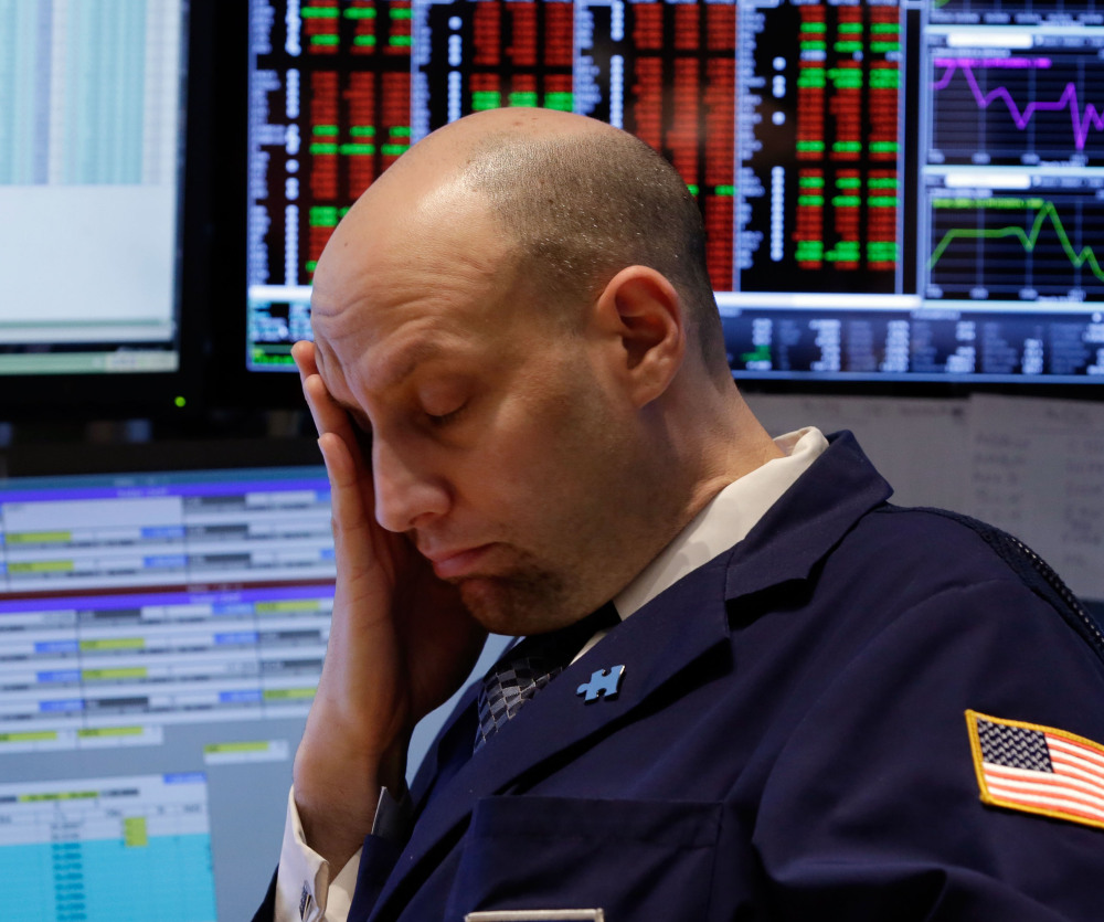 Specialist Meric Greenbaum works at his post last week on the floor of the New York Stock Exchange. U.S. stocks fell Monday as tensions with Russia escalated.