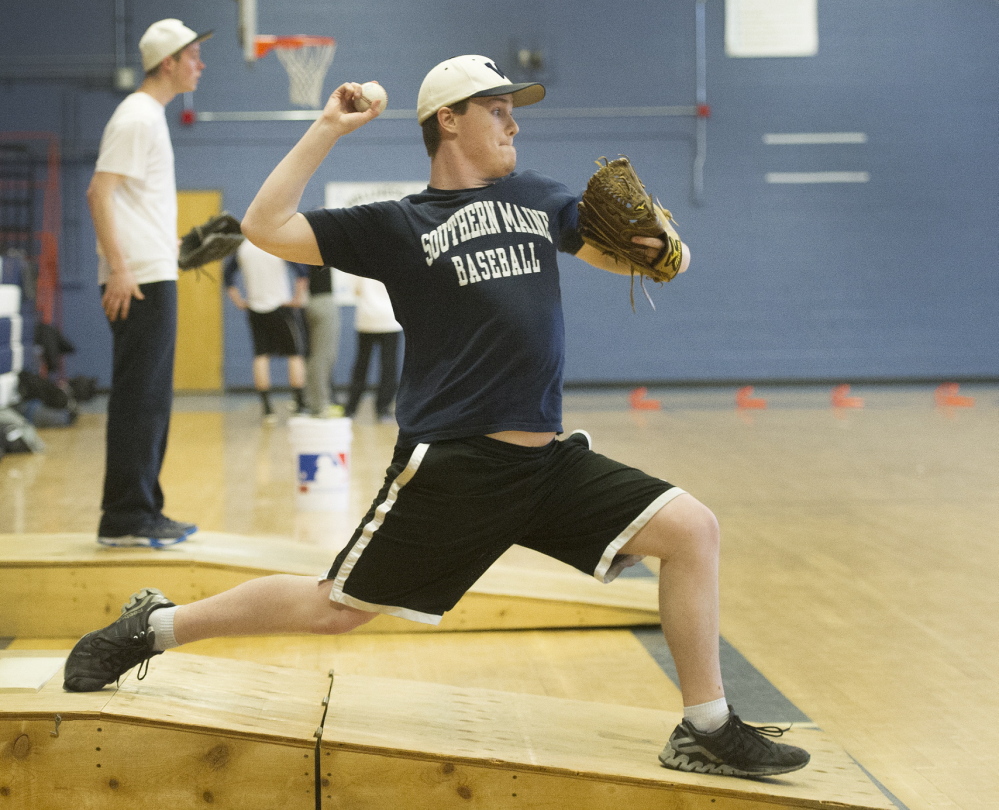 Westbrook’s Ethan Nash, a senior pitcher, throws off a fabricated mound in the gym on Monday, as schools across the state started preparing for the spring sports season.
