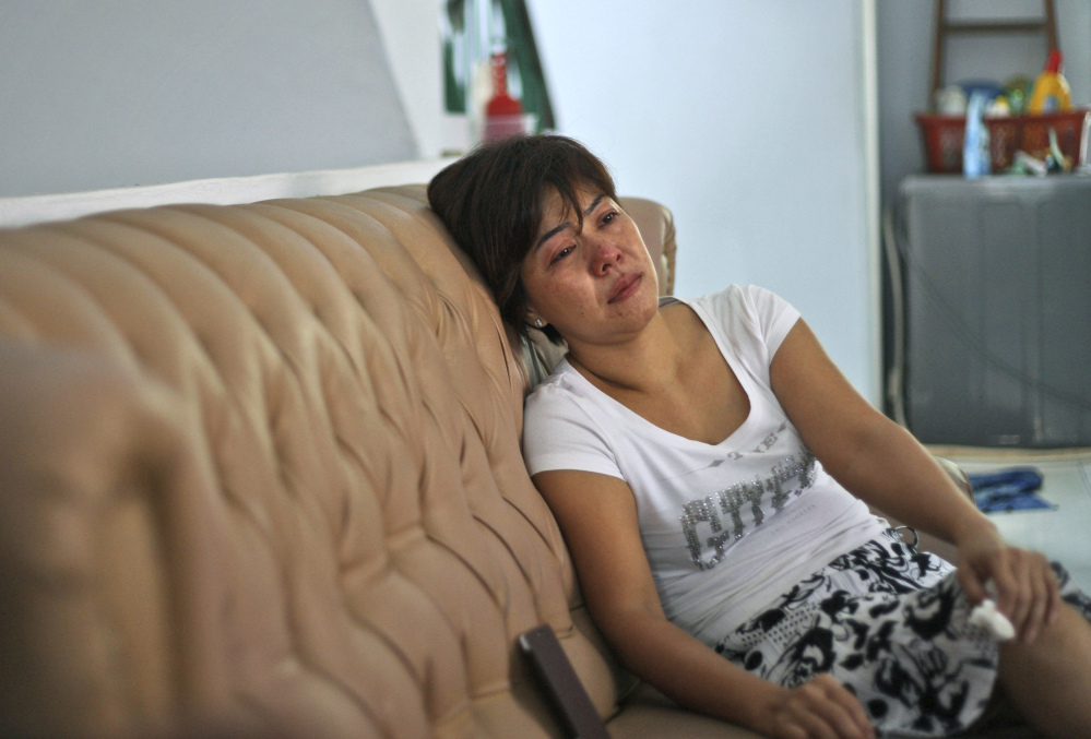 Yenny, the sister of Sugianto Lo who was onboard the Malaysia Airlines plane MH370, weeps on the couch as she watches a news update on the search of the wreckage of the jetliner at their family residence in Medan, North Sumatra, Indonesia, Tuesday, March 25, 2014. After 17 days of desperation and doubt over the missing Malaysia Airlines jet, the country’s officials said an analysis of satellite data points to a “heartbreaking” conclusion: Flight 370 met its end in the southern reaches of the Indian Ocean, and none of those aboard survived.