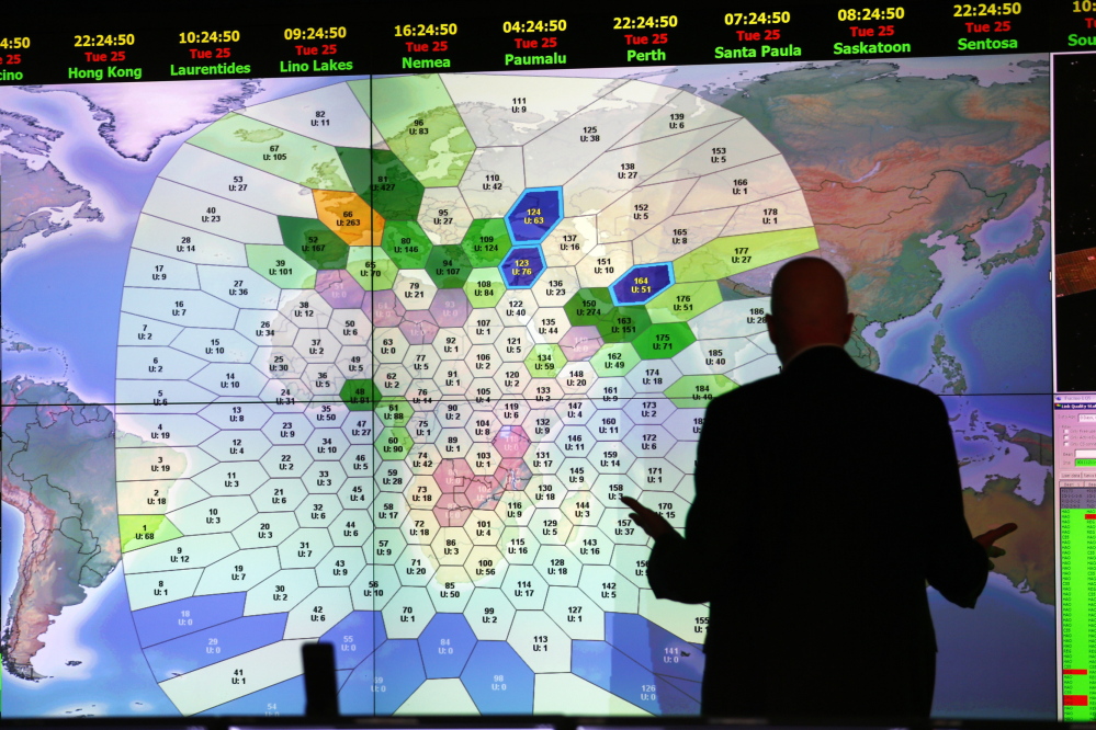 A staff member at London satellite communications company Inmarsat works in front of a screen showing subscribers using their service throughout the world. Inmarsat used a wave phenomenon discovered in the 19th century to analyze the seven pings its satellite picked up from Malaysia Airlines Flight MH370 to determine its final destination.
