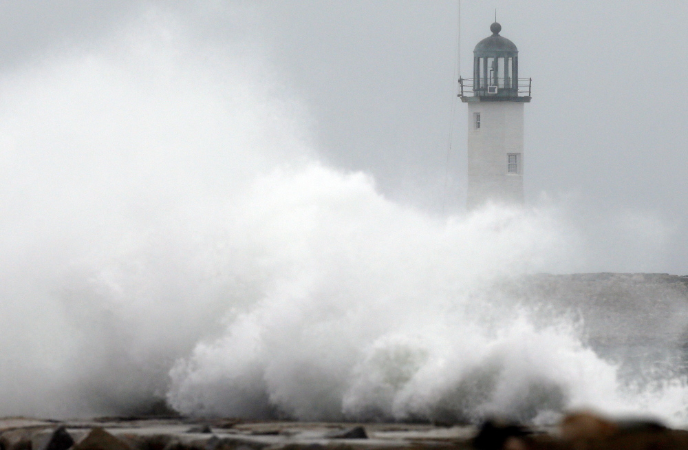 Wind-driven waves crash on a sea wall in front of Scituate Lighthouse in Scituate, Mass., on Wednesday.