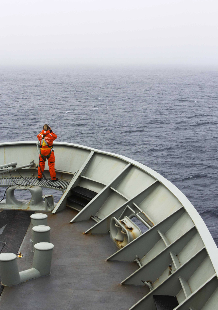 A lookout is stationed on the bow of HMAS Success during the search in the southern Indian Ocean for signs of missing Malaysia Airlines Flight MH370. The desperate, multinational hunt resumed Wednesday across a remote stretch of the Indian Ocean after fierce winds and high waves that had forced a daylong halt eased considerably.