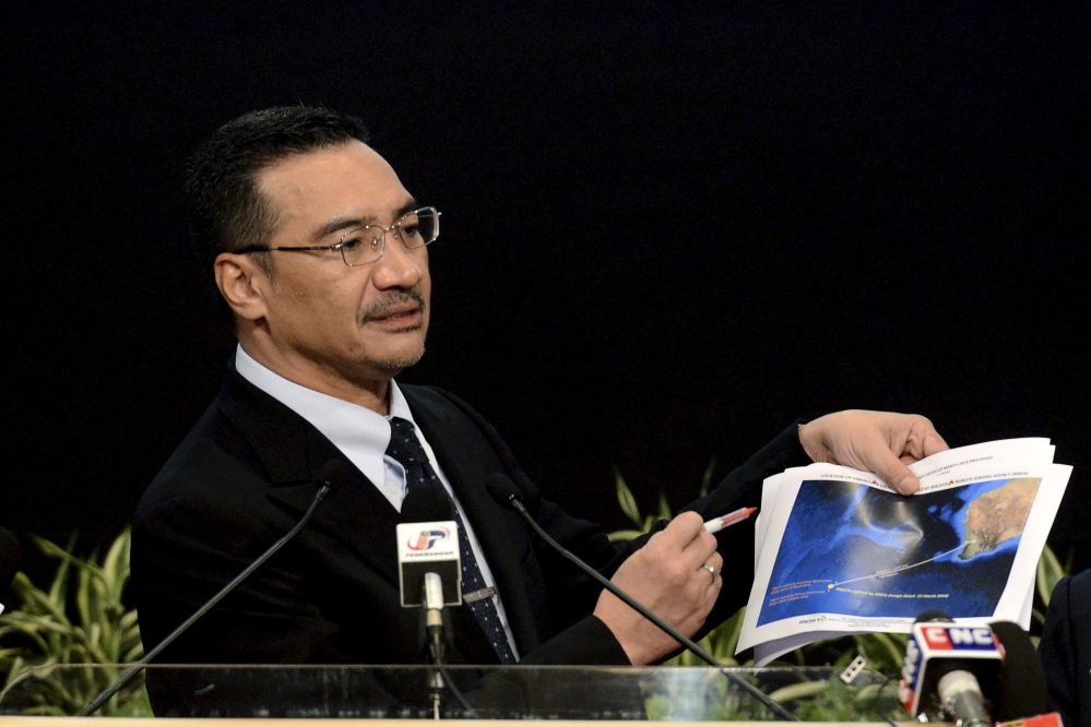 The Associated Press Malaysia’s Defense Minister and acting Transport Minister Hishammuddin Hussein shows a printout of the latest satellite image of objects that might be from the missing Malaysia Airlines plane, on March 26, 2014.