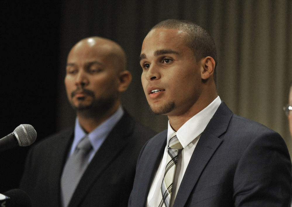 Northwestern quarterback Kain Colter, right, speaks while College Athletes Players Association President Ramogi Huma listens during a news conference in Chicago in January. In a landmark ruling, a federal agency on Wednesday gave football players at Northwestern University the green light to unionize.
