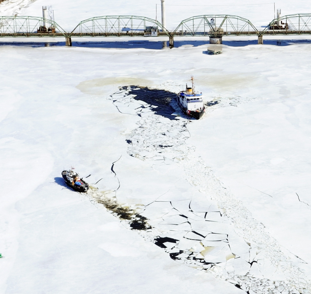 The 65-foot U.S. Coast Guard cutter Bridle, left, and the 140-foot Thunder Bay turn around Thursday near the Richmond-Dresden Bridge on the Kennebec River. They started breaking ice in Bath in the morning.