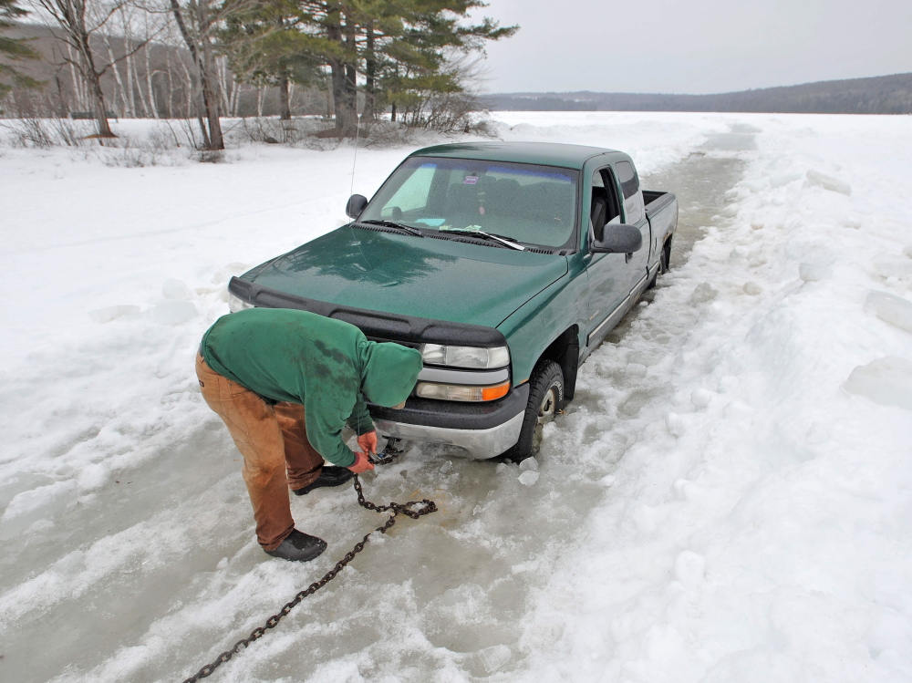 soft ice: Steve Richardson, 28, of Clinton, tries to free his pickup truck Friday from Lake George in Canaan after trying to get his ice fishing shack off the ice ahead of an April 1 deadline. Richardson’s truck broke through about 2 feet of ice, coming to rest on another layer of ice and lake water.