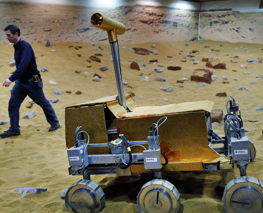 An engineer walks past a robotic vehicle on the “Mars Yard” testing ground for the European Space Agency’s ExoMars program in Stevenage, England.