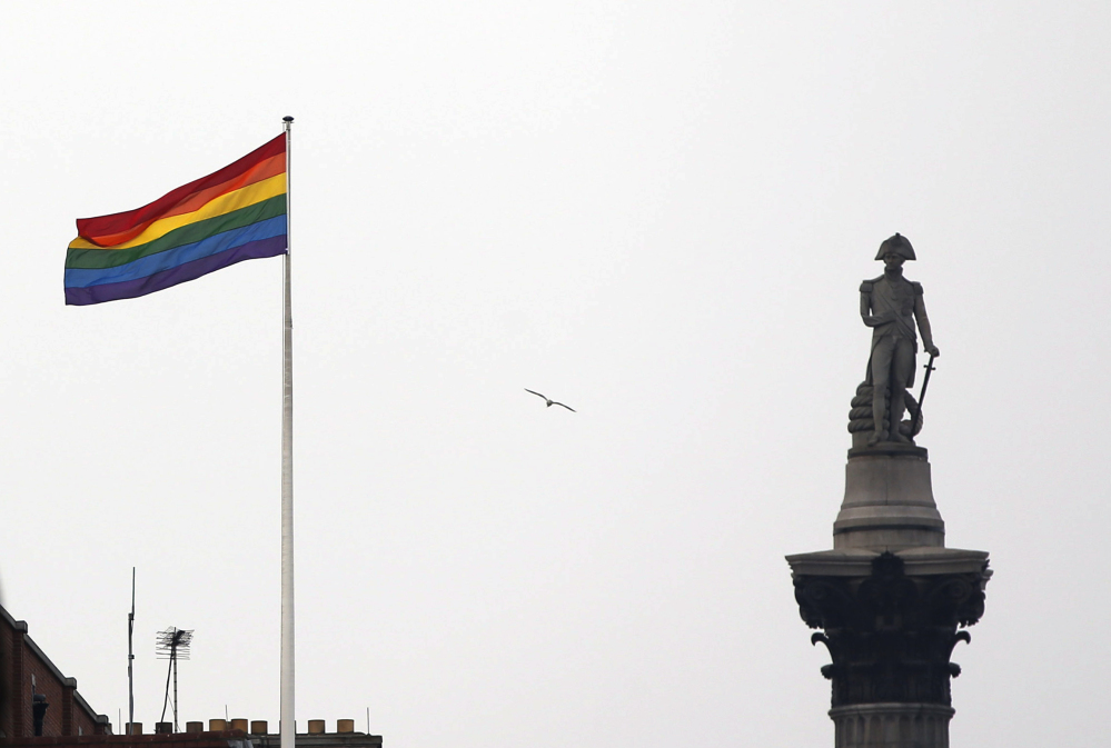 The rainbow flag, a symbol of lesbian, gay, bisexual, and transgender community, flies over a building next to Nelson's Column in Trafalgar Square in London on Friday to mark the start of same-sex weddings in the UK on Saturday.