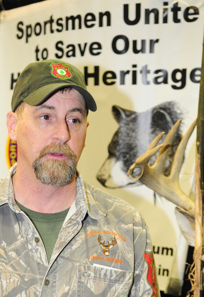 Bear hunting guide Matt Whitegiver answers a question about the pending bear hunt referendum Saturday at the State of Maine Sportsman’s Show in the Augusta Civic Center.