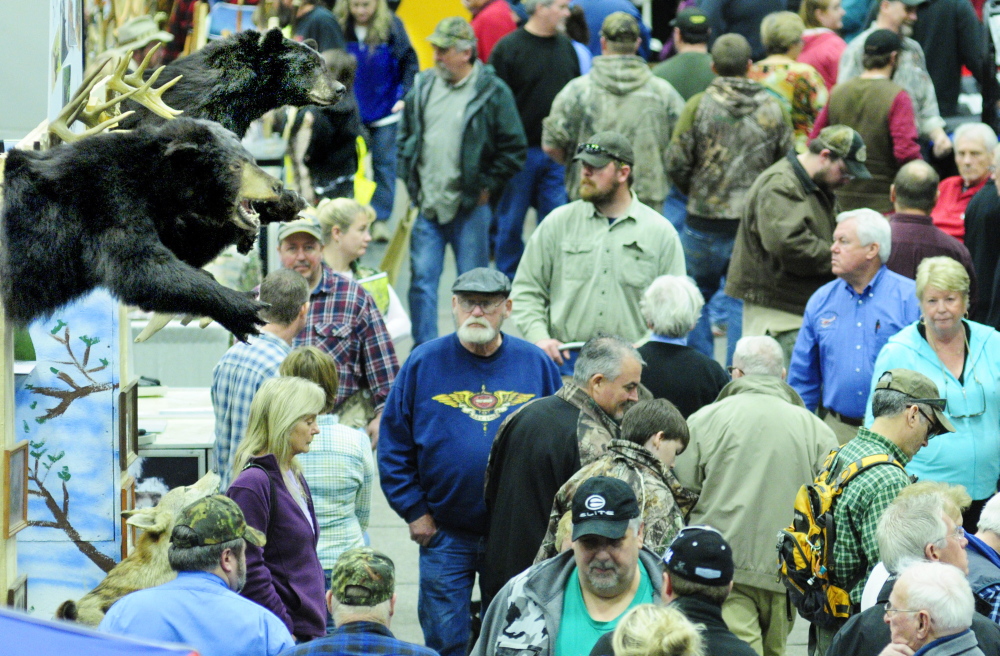 Showgoers walk past a booth with stuffed bears on display Saturday during the State of Maine Sportsman’s Show at the Augusta Civic Center.
