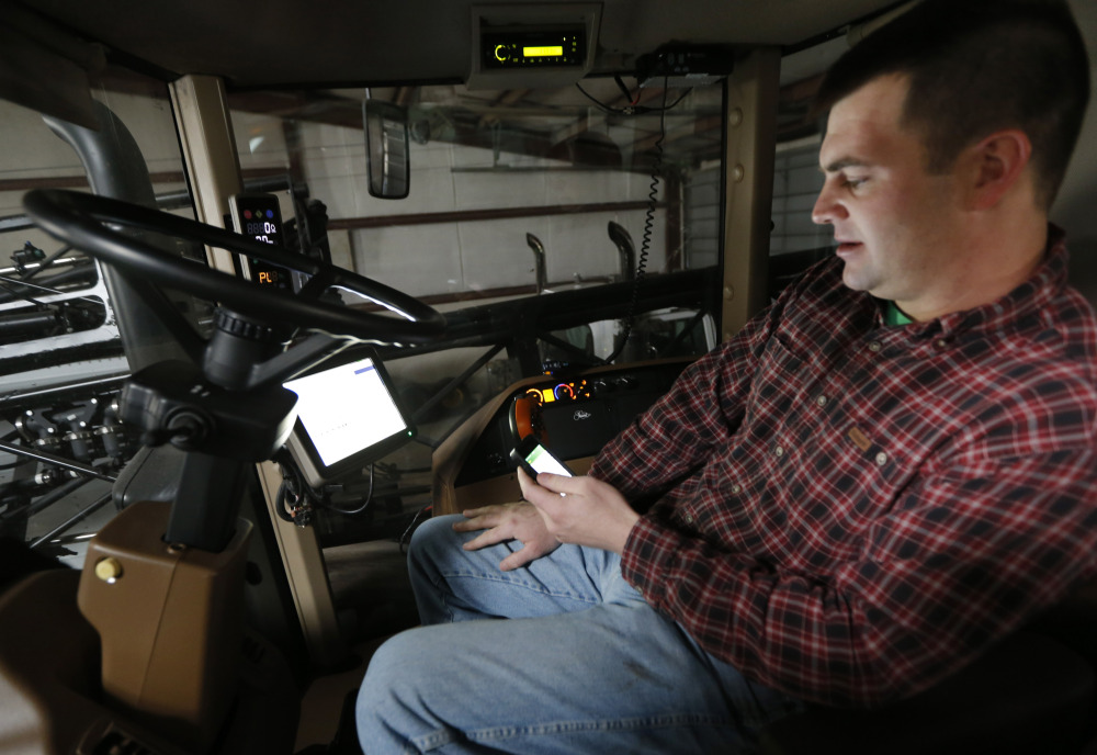 Nick Guetterman looks over the data shared by his crop sprayer and cell phone while on his farm near Bucyrus, Kan., Wednesday.