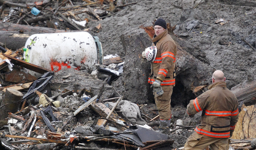Searchers pause for a moment of silence Saturday at the scene of the mudslide in Oso, Wash.