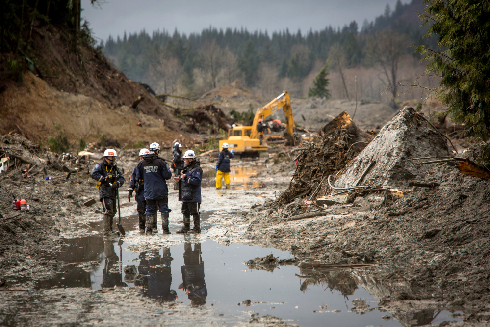 As rain adds to the danger, rescue workers continue to search the muck and debris left by the Oso mudslide along State Route 530 near Darrington, Wash.
