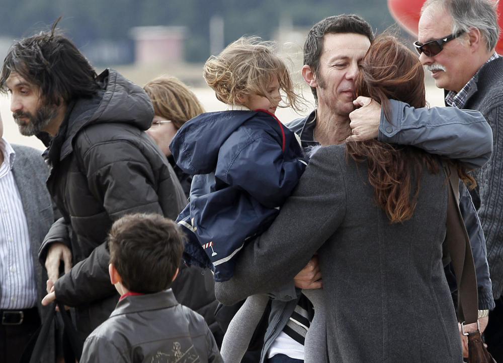 Spanish reporter Javier Espinosa, second right, holds his daughter, Nur, as he is greeted by his wife, Monica Garcia, upon his arrival at the military airport of Torrejon in Madrid, Spain, on Sunday. Espinosa and fellow journalist Ricardo Garcia Vilanova were freed after being kidnapped for more than six months in Syria by a rogue al-Qaida group.