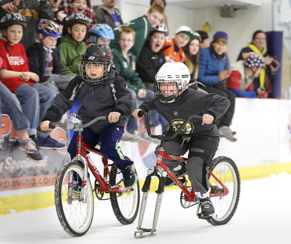 Cameron Bourgue, left, edges out Maverick White, both 7 years old and from Biddeford, on Sunday during a bike race on ice at the Biddeford Ice Arena to benefit the Community Bicycle Center.