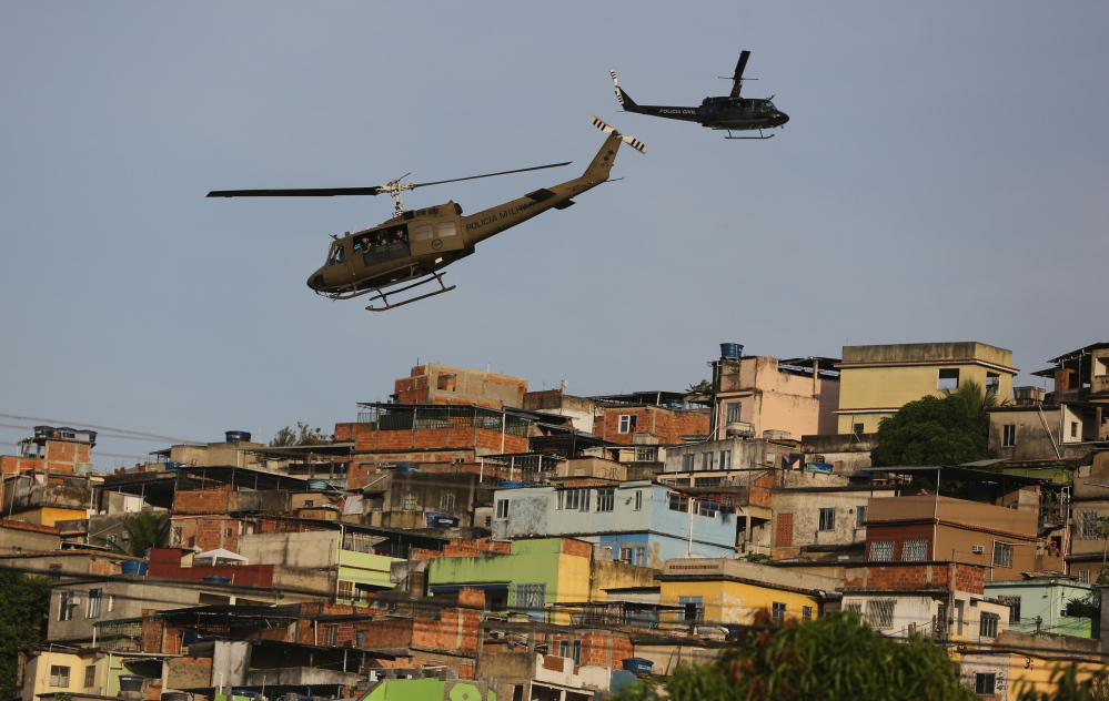 Police helicopters fly over the Mare slum complex in Rio de Janeiro, Brazil, on Sunday as 14,000 police and Marines move in on the area. The operation is part of a “pacification effort that began in 2008 to secure Rio before this year’s World Cup.