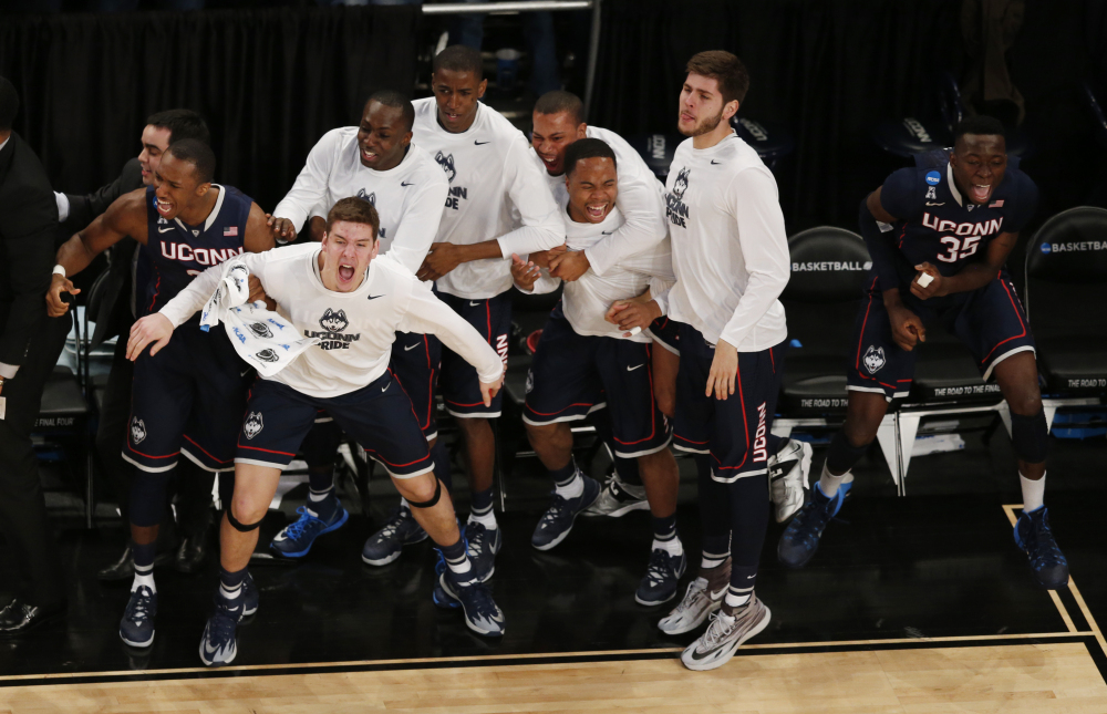 Connecticut players react during the second half in a regional semifinal at the NCAA college basketball tournament against the Michigan State, Sunday, in New York.