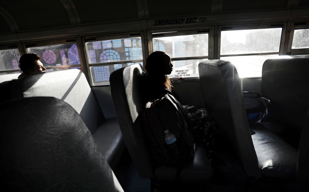 Kera Pingree, 17, left, and Dylantha Musonerwa, 14, ride the late bus home from Deering High School. Several juniors pushed to institute a late bus and found $8,000 in a fund for co-curricular activities to pay for the bus three days a week as a pilot project.